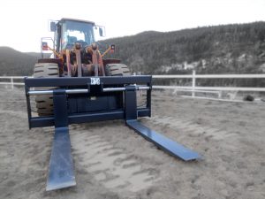 Heavy duty grey wheel loader pallet forks.  Used to handle and maneuver objects.  Manufactured by Tysea Mfg available for rent through Rush Rentals Ltd.